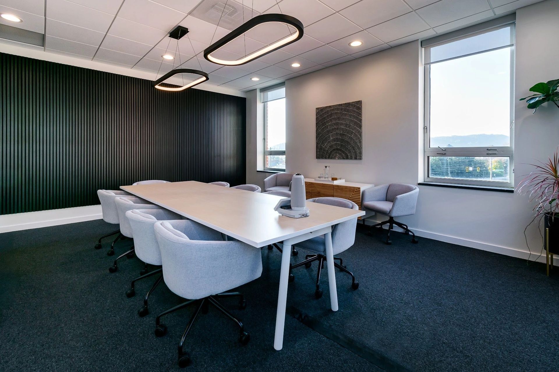 Modern conference room with light gray chairs and a long table.