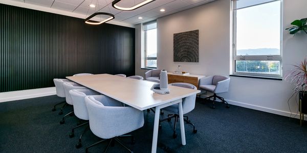 Modern conference room with light gray chairs and a long table.