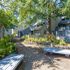 Sunlit courtyard with benches and greenery in a residential complex.