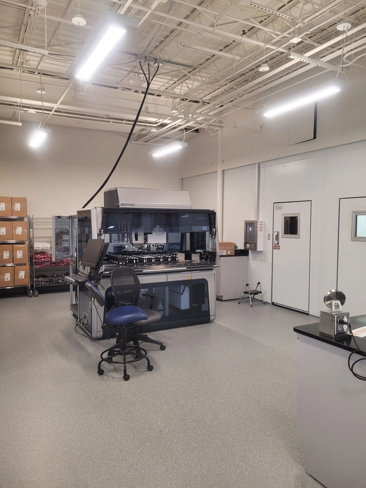 A clean lab with medical equipment and chairs.