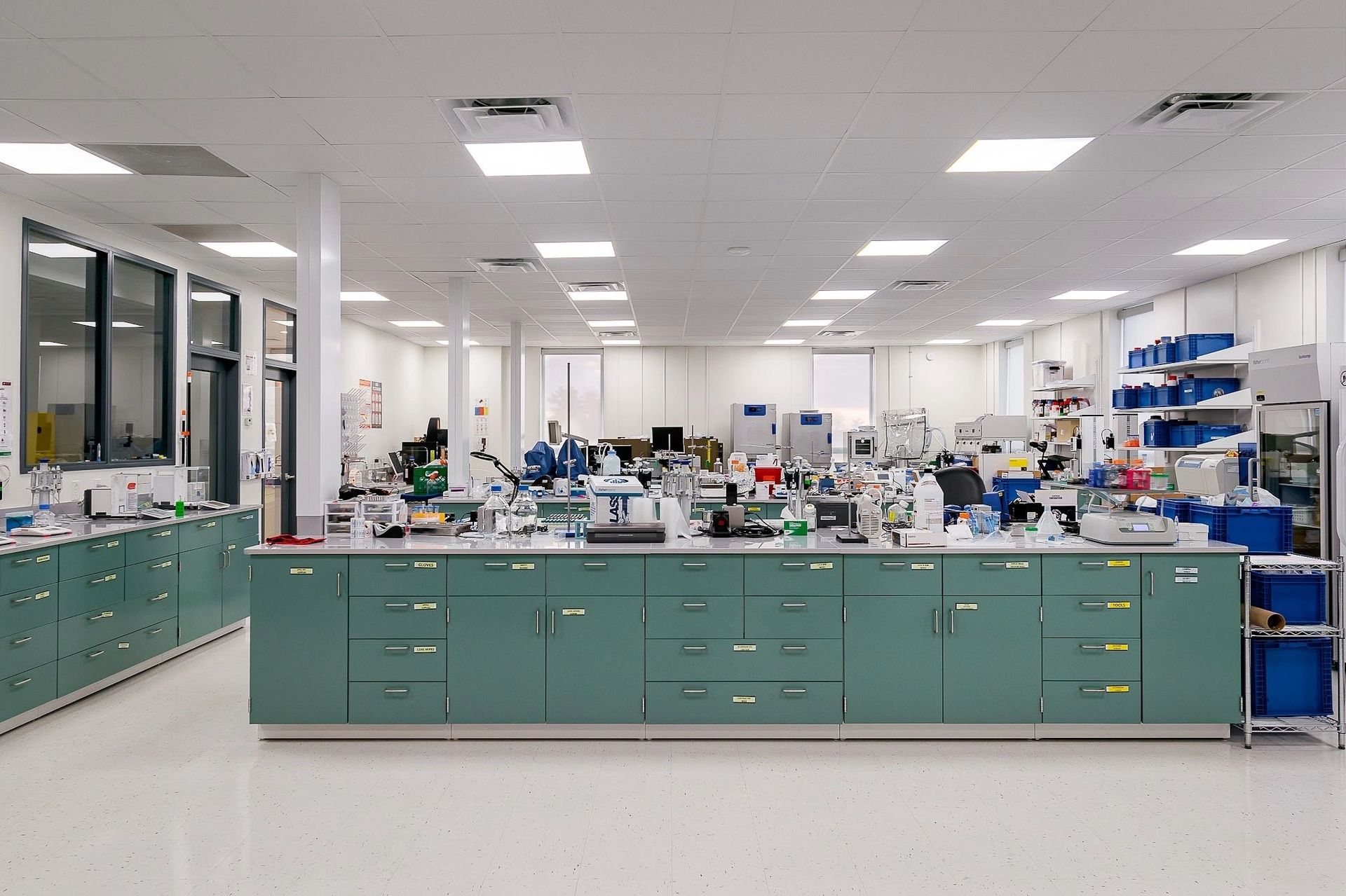A clean, well-organized laboratory with green cabinets and scientific equipment.