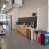 Modern office kitchenette with recycling bins and appliances.